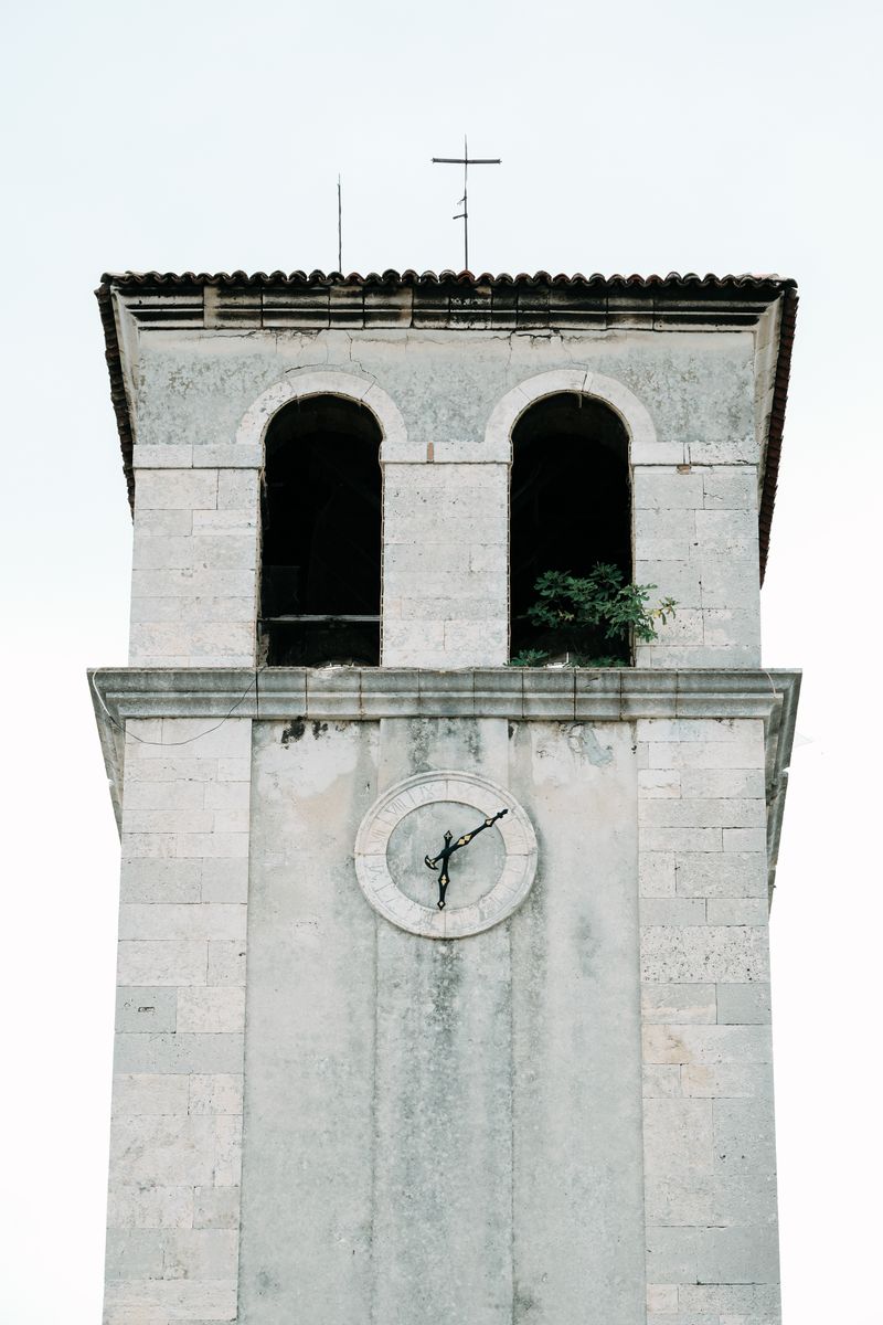 A detailed view of a historic clock tower in Croatia showcasing classical architecture.