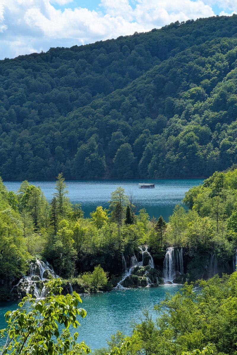 A tranquil landscape with waterfalls at Plitvice Lakes National Park, Croatia, surrounded by lush greenery.