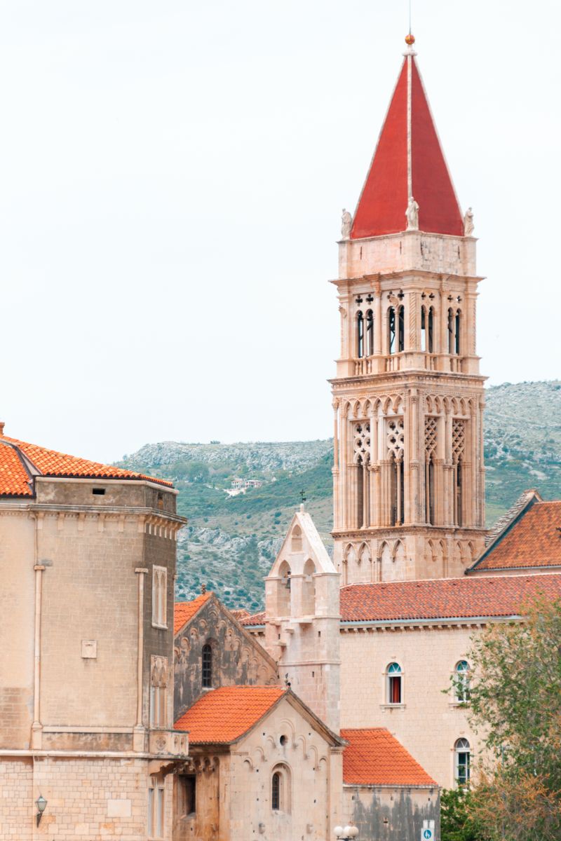 Gothic-style bell tower of St. Lawrence Cathedral in Trogir, Croatia, in a picturesque outdoor setting.