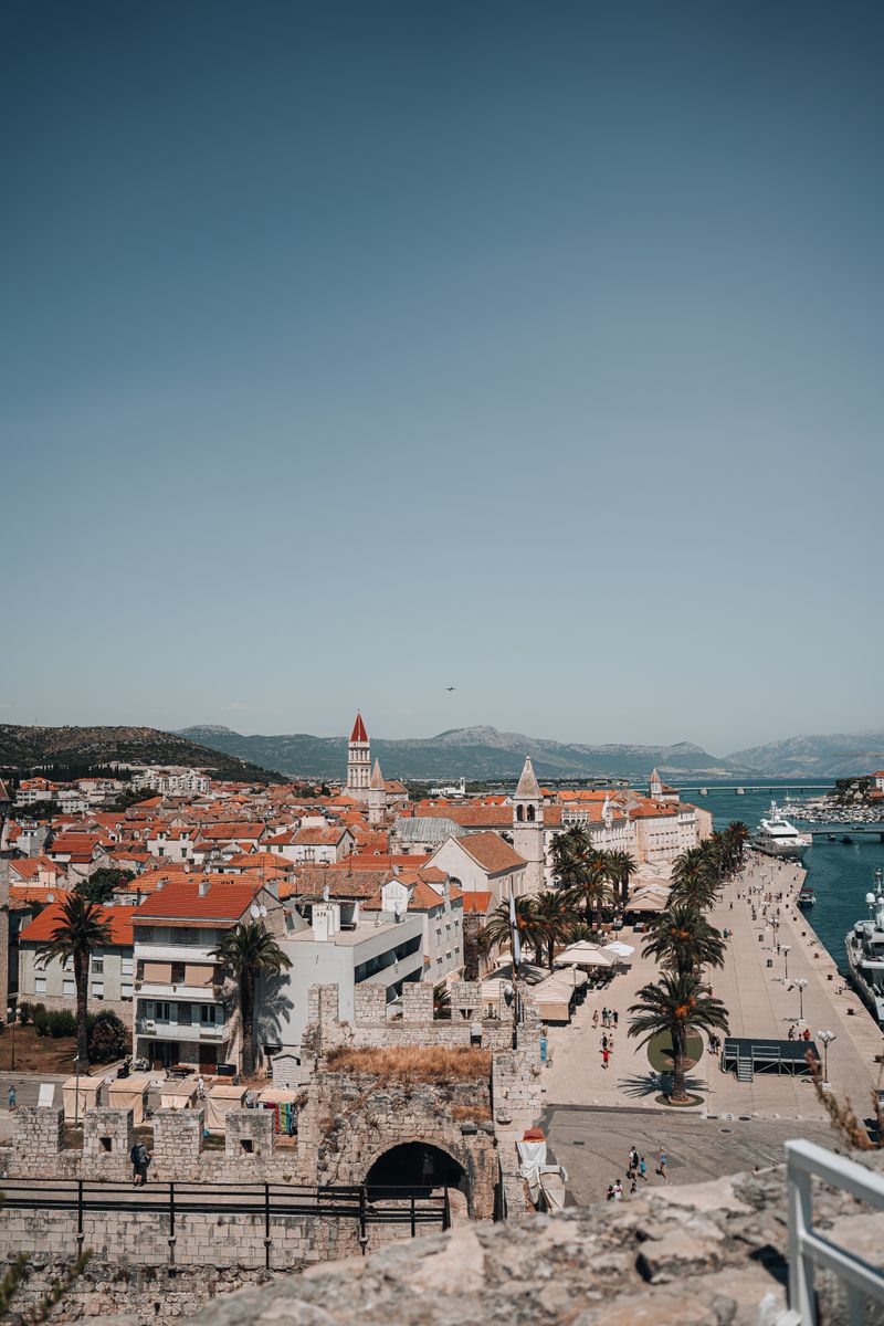 Aerial view of Trogir, Croatia showcasing red rooftops, coastline, and historic architecture.