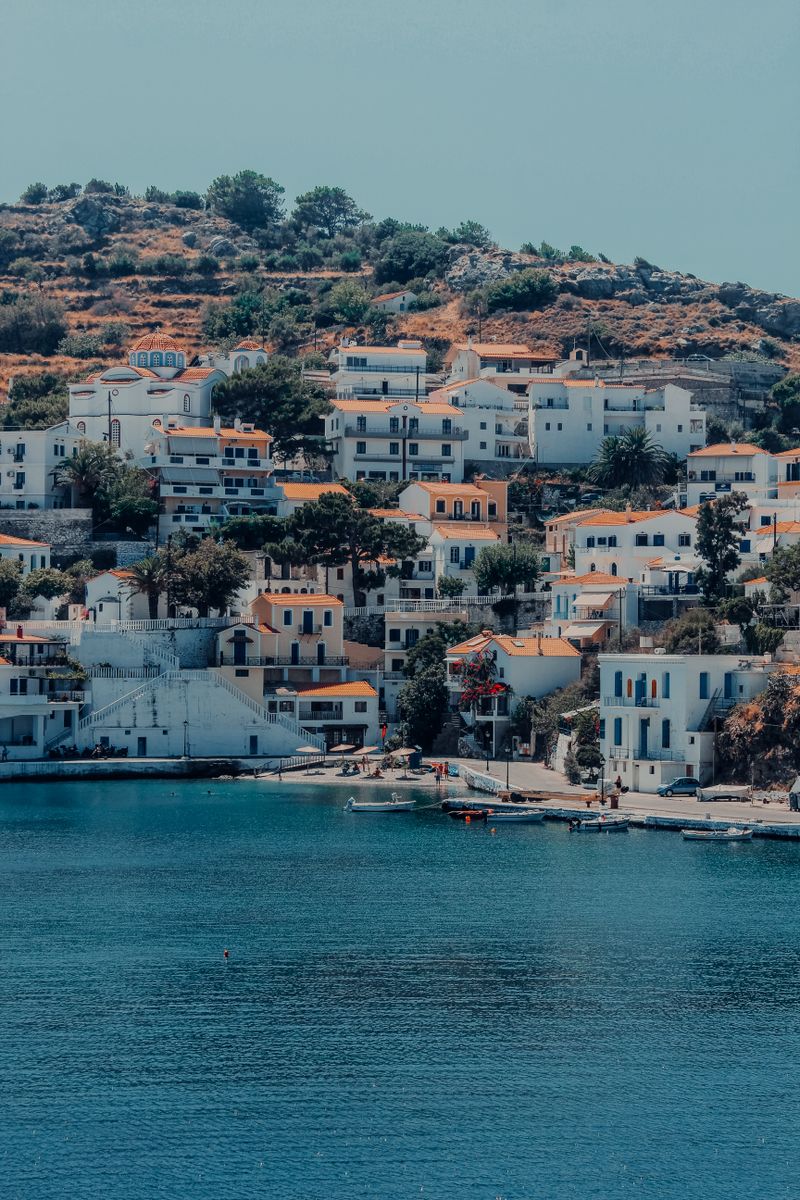 Charming coastal village in Greece with traditional white architecture overlooking a serene bay.